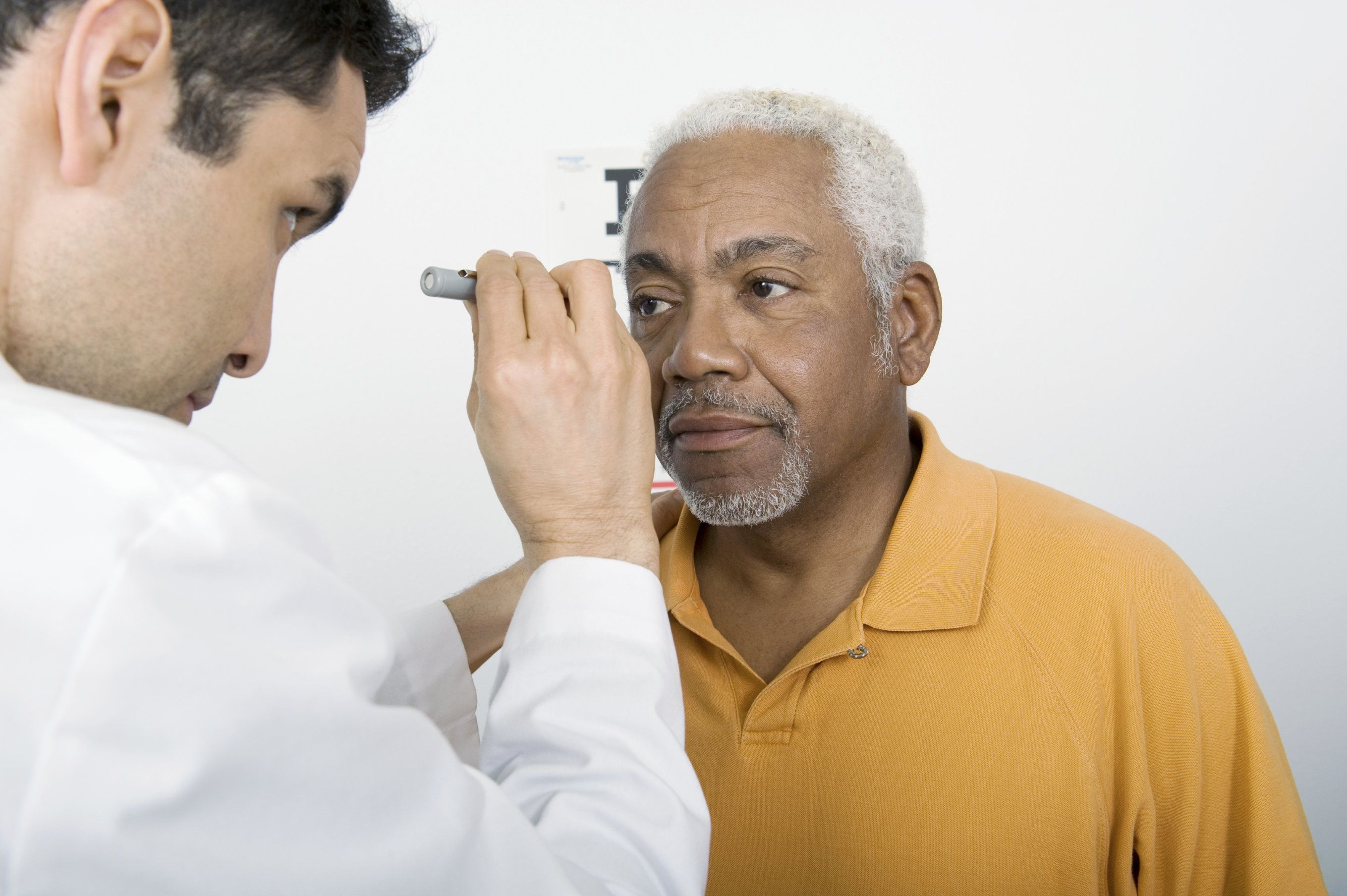 ophthalmologist performing an eye exam on a male patient