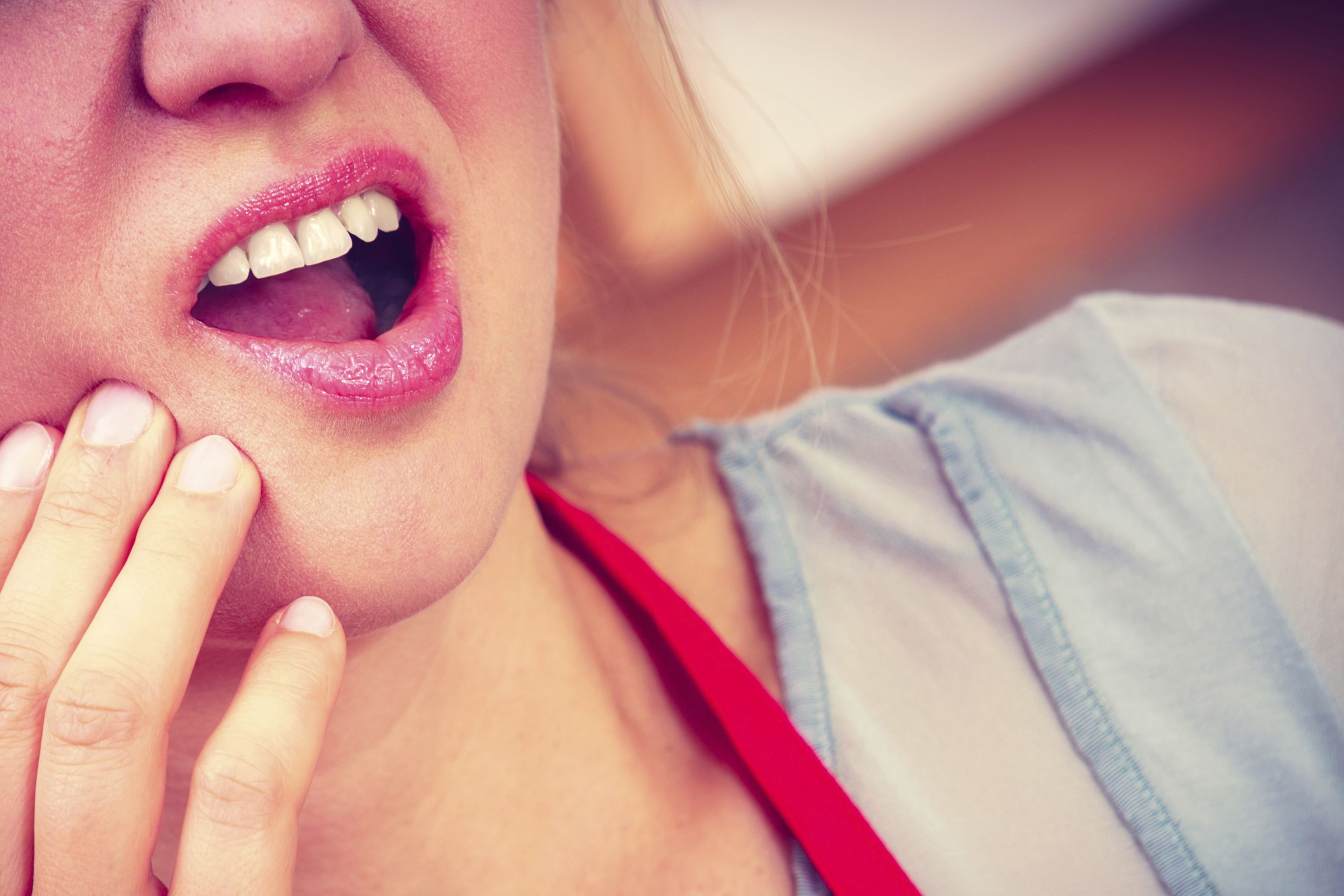 person holding their jaw in pain