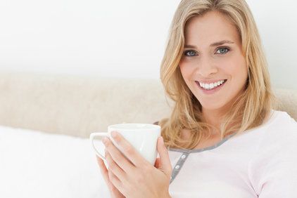 Smiling blond woman holding coffee cup