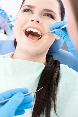 A young female patient having her teeth examined