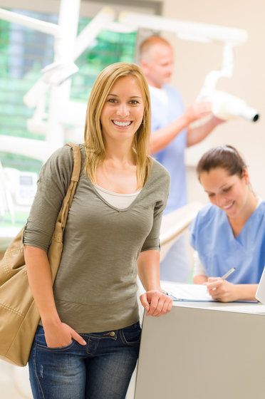 A young woman leaving a dental office