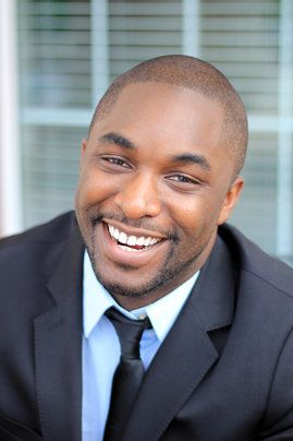 A man in a suit with a bright, healthy smile