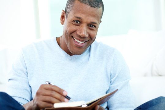 A happy man writing in a journal.