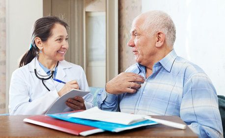 Elderly patient conversing about treatment options with doctor