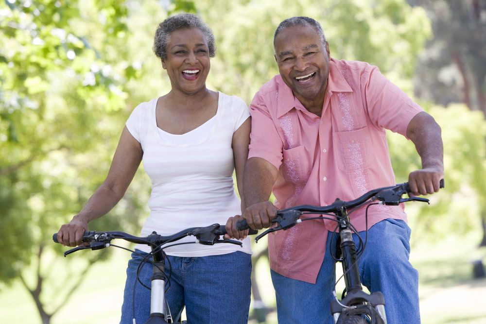 Older couple smiling while riding bikes