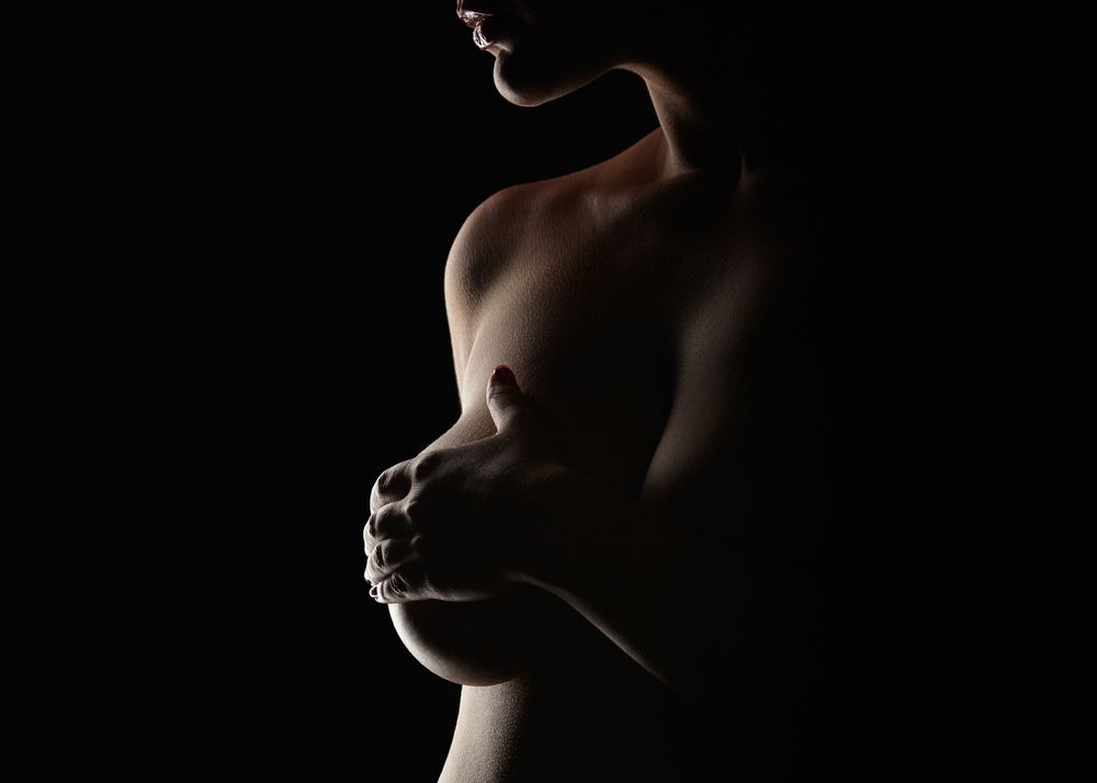 A woman holding her hand over her breast