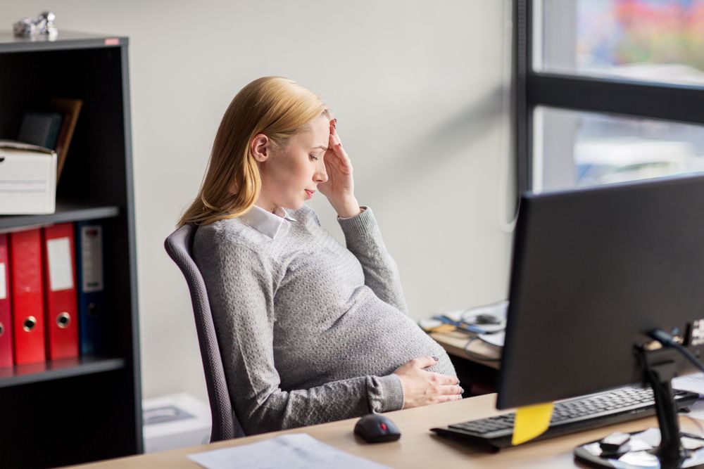 A pregnant woman sitting by a computer