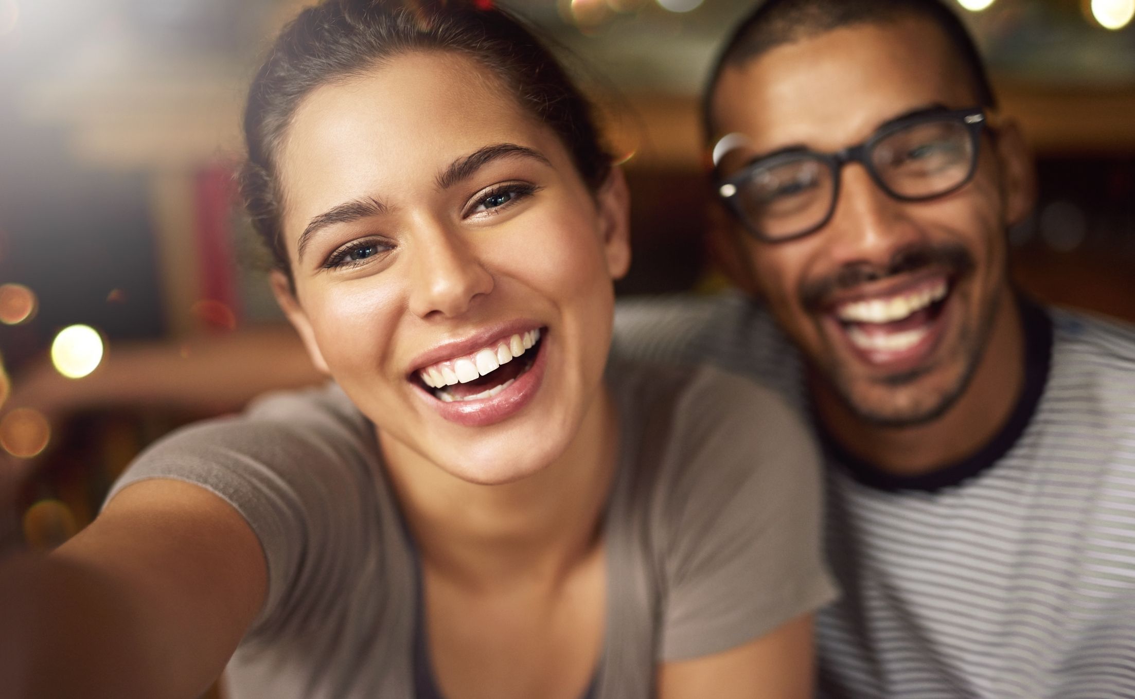 Smiling couple with woman reaching towards camera