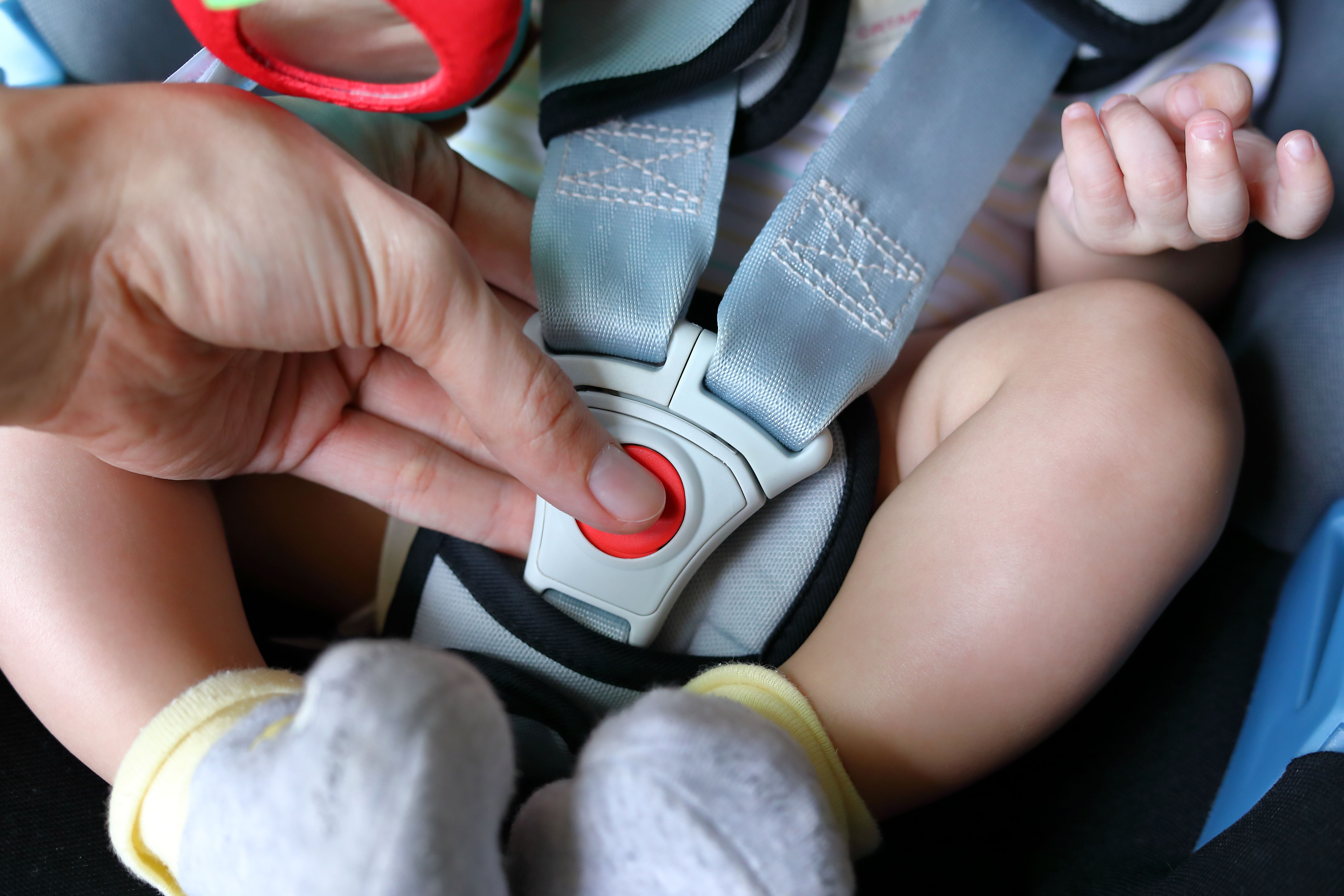 A baby being strapped in a car seat