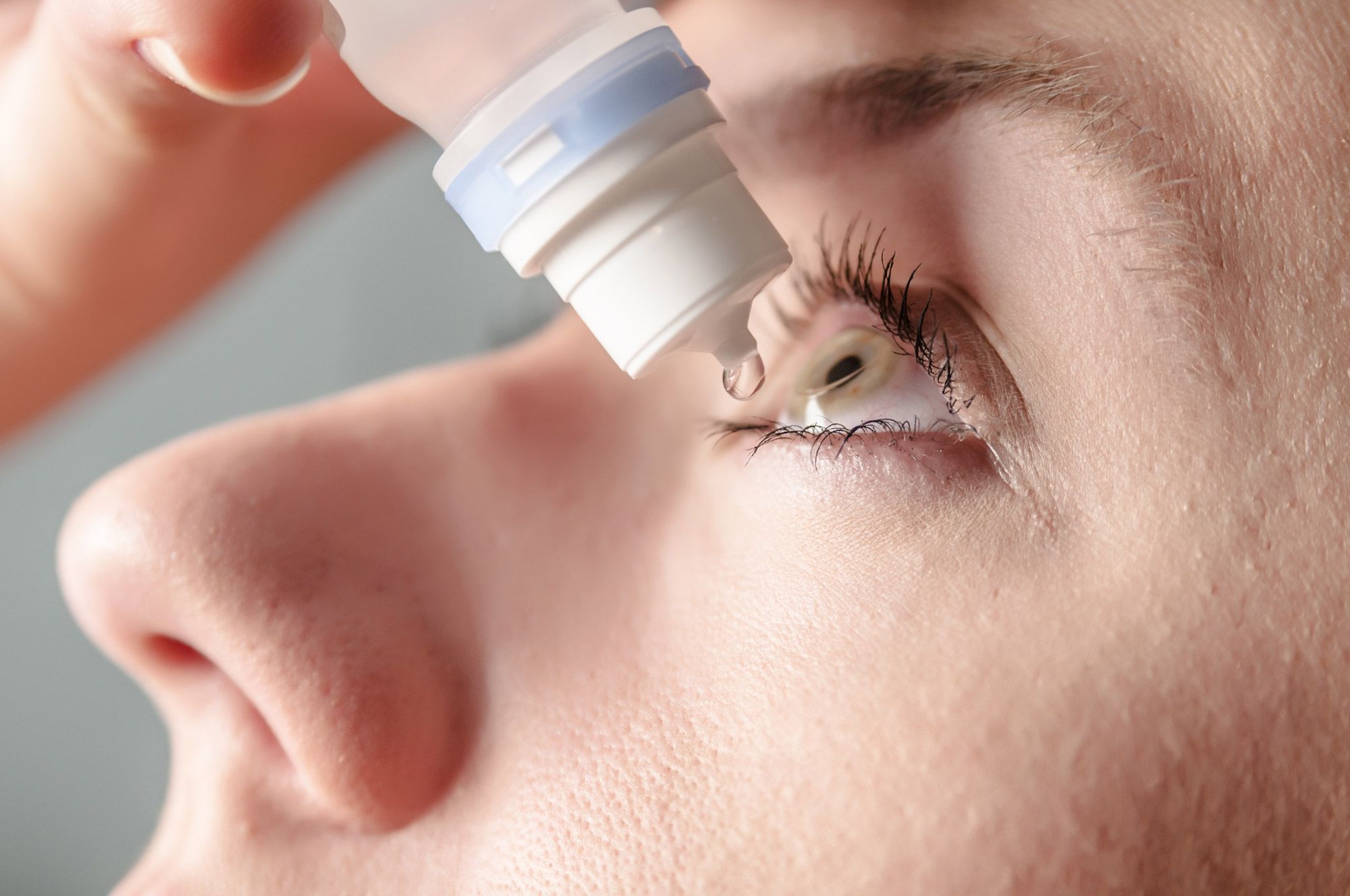 woman using artificial tears on her dry eyes