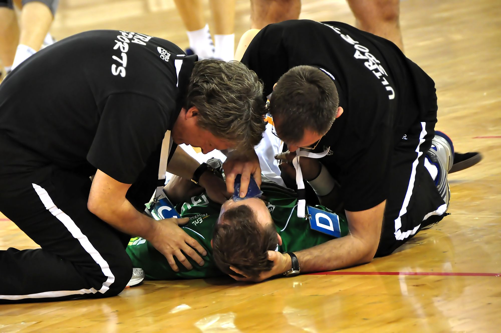 Referees attending to basketball player laying on court