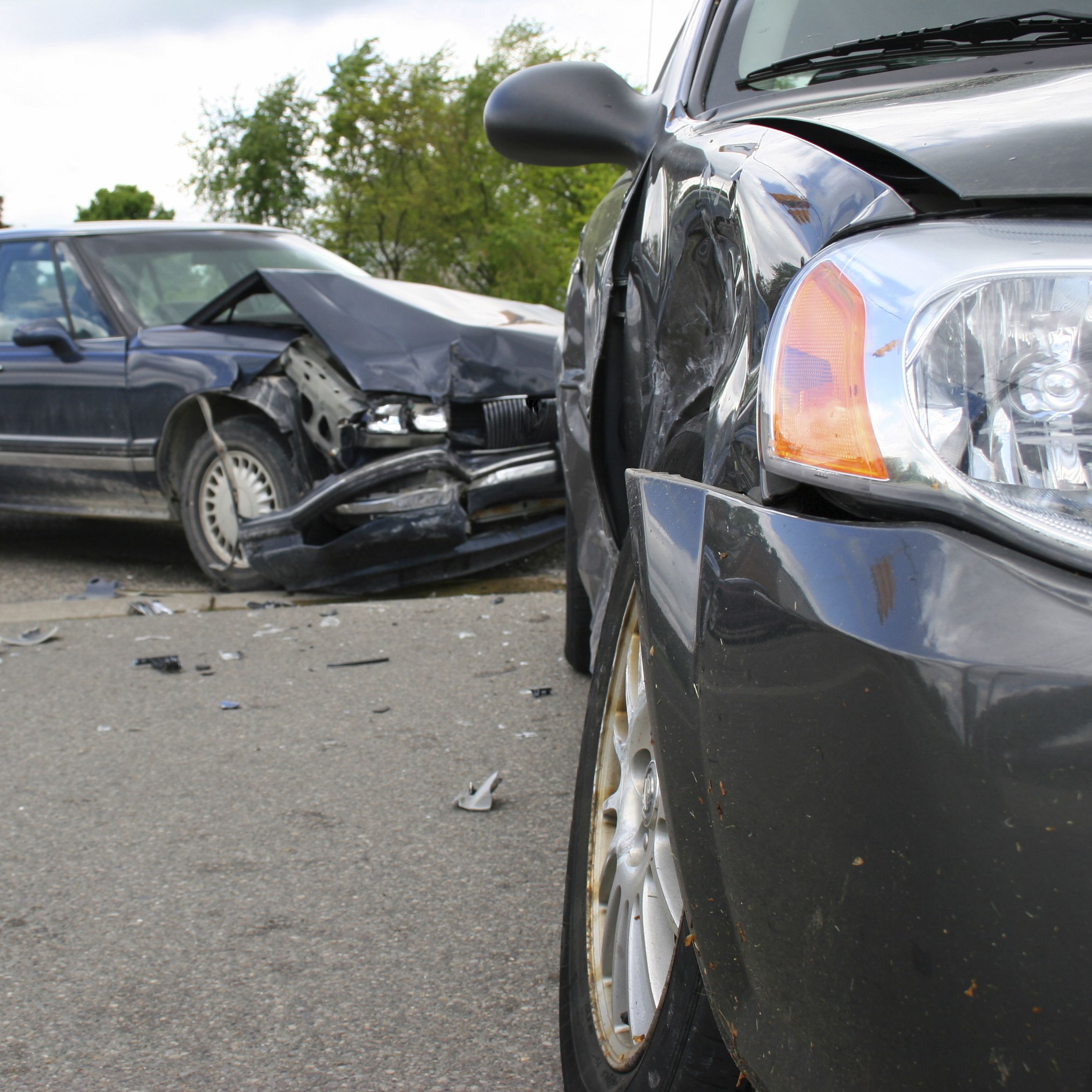 Two cars, both damaged after a collision caused by defective tires