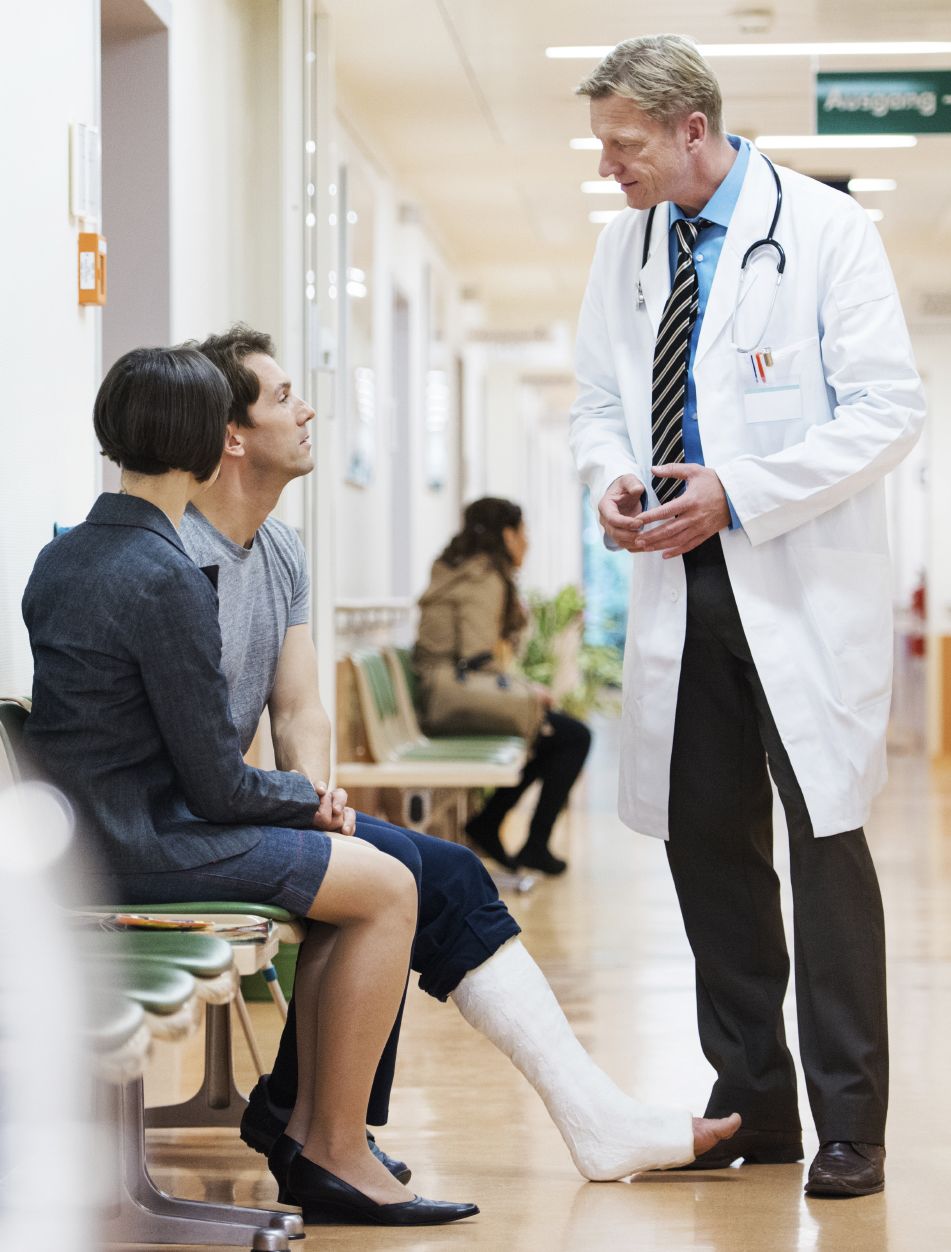 doctor speaking with a man who has a cast on his leg