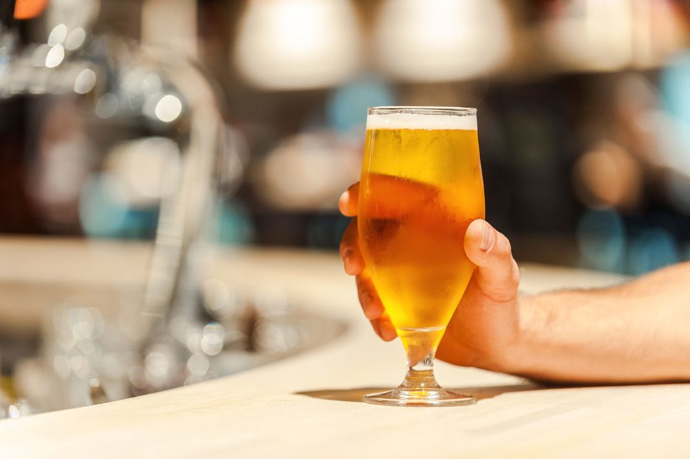 A hand holding a glass of alcohol