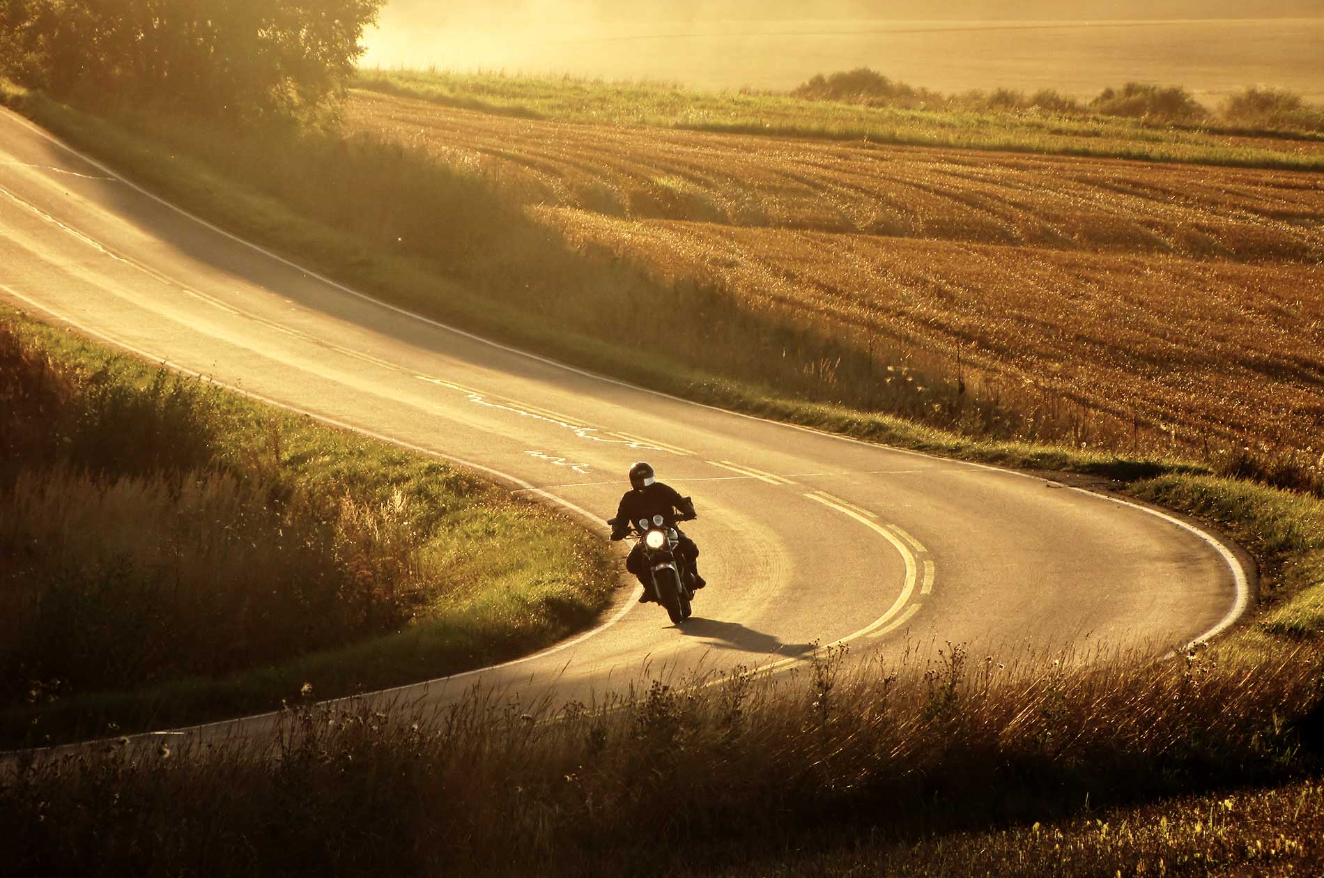 motorcyclist riding down a rural road