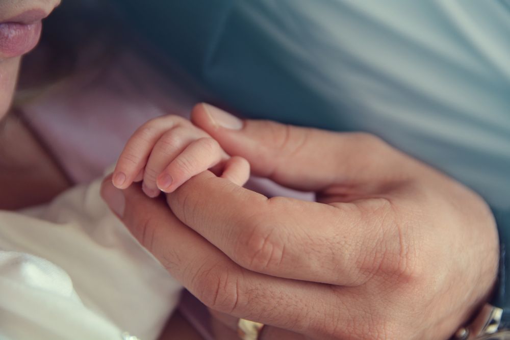 father holding his baby’s hand