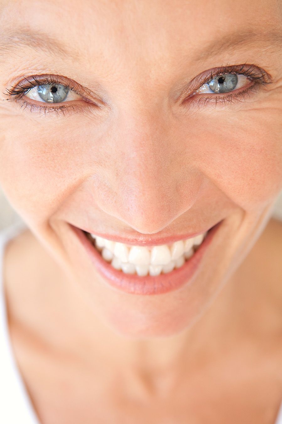 Blue-eyed woman with a straight and pristine smile