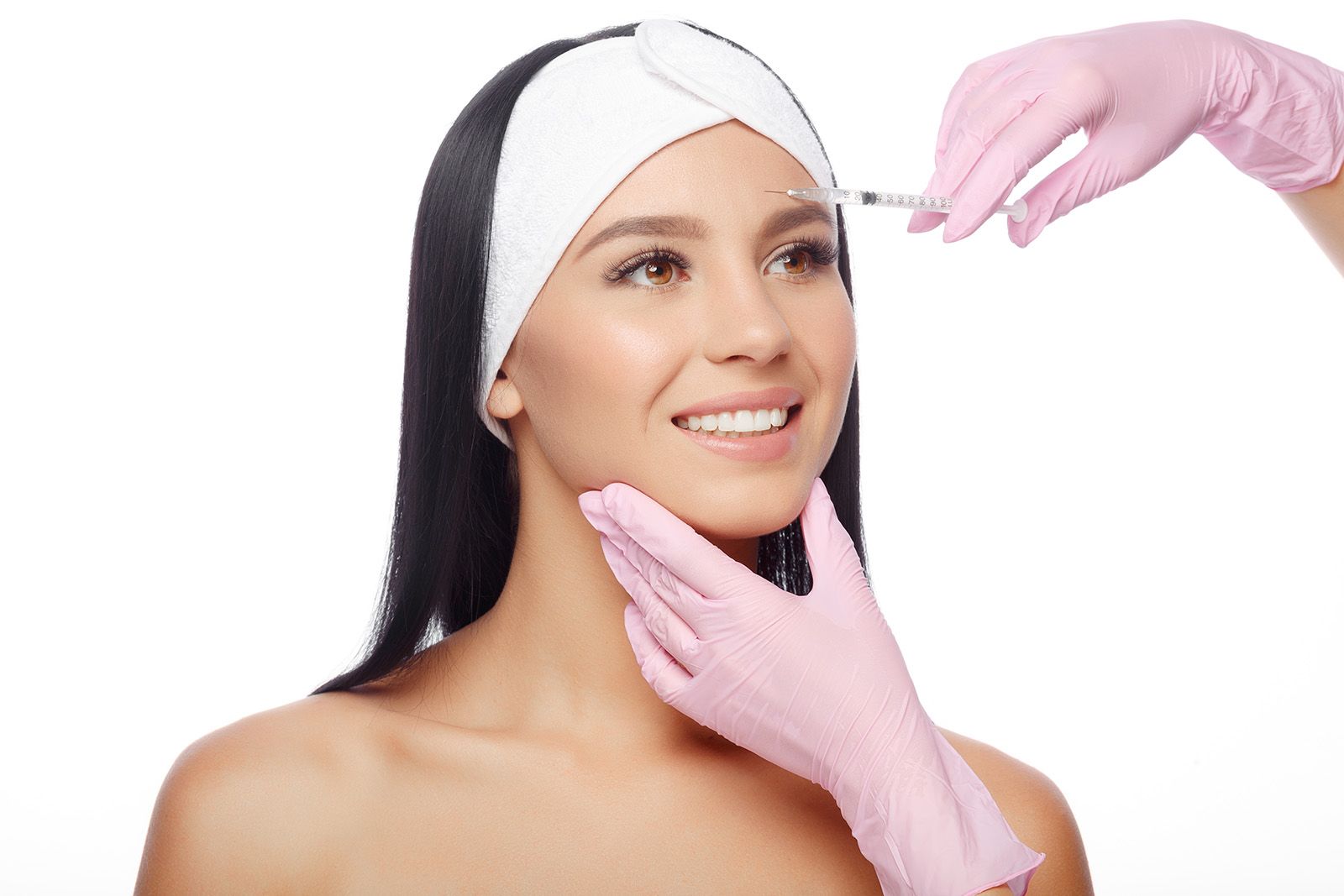 A youthful looking woman receiving Botox injections in her forehead