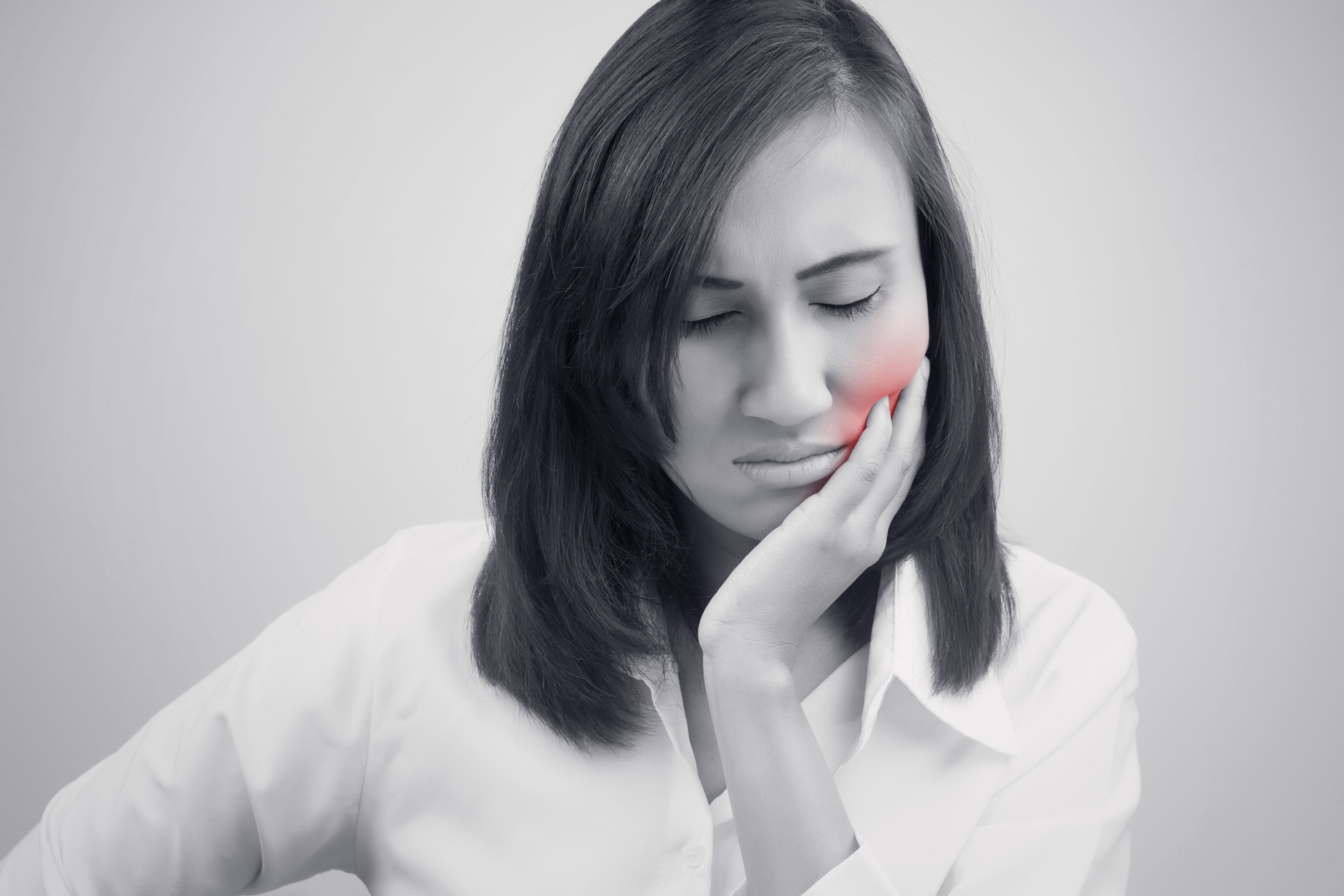 A woman holding her jaw in pain
